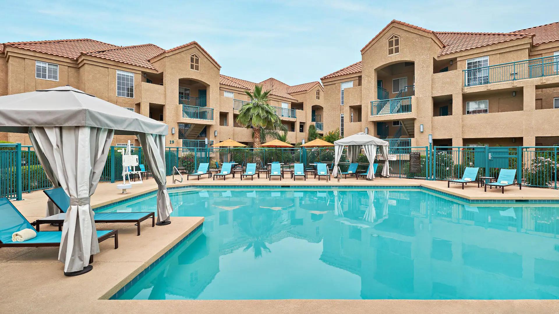 Swimming pool surrounded by blue sunbeds at the Hyatt House Scottsdale Old Town