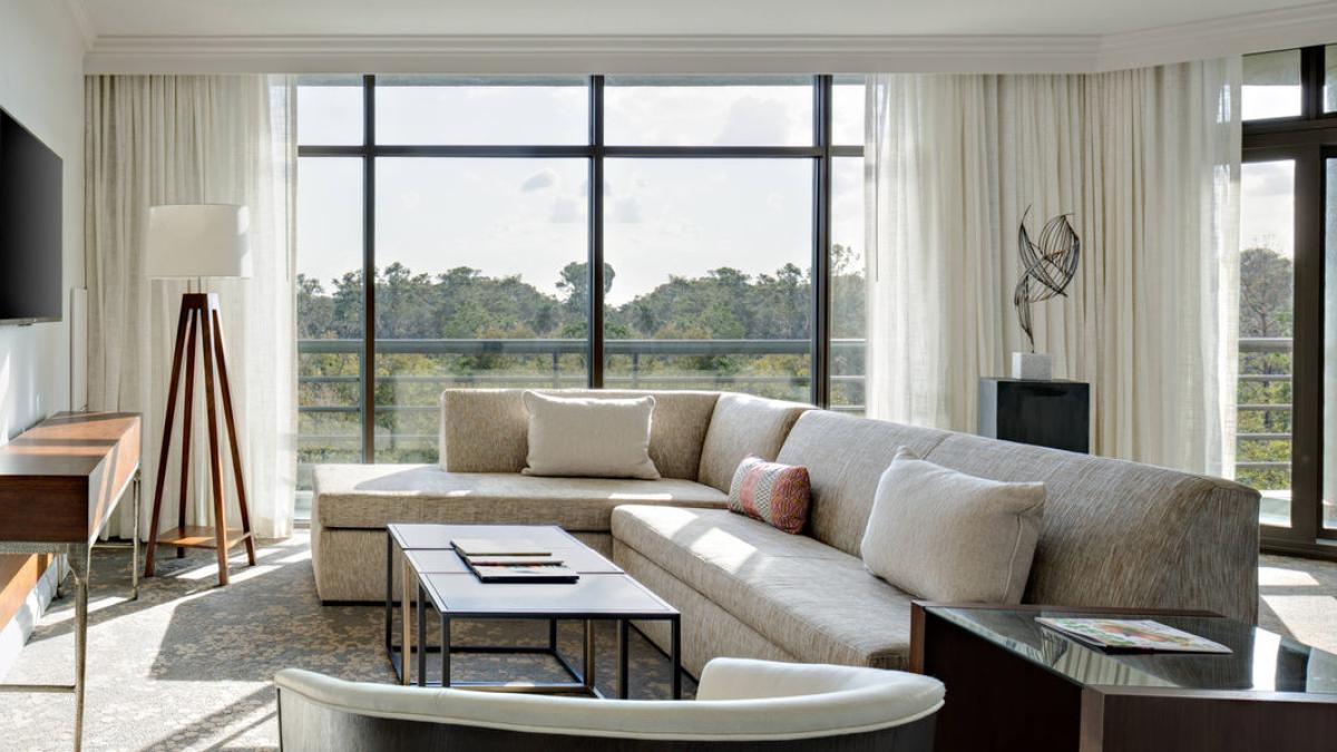 Sitting room part of a suite in the resort with panoramic windows and balcony views of the nature