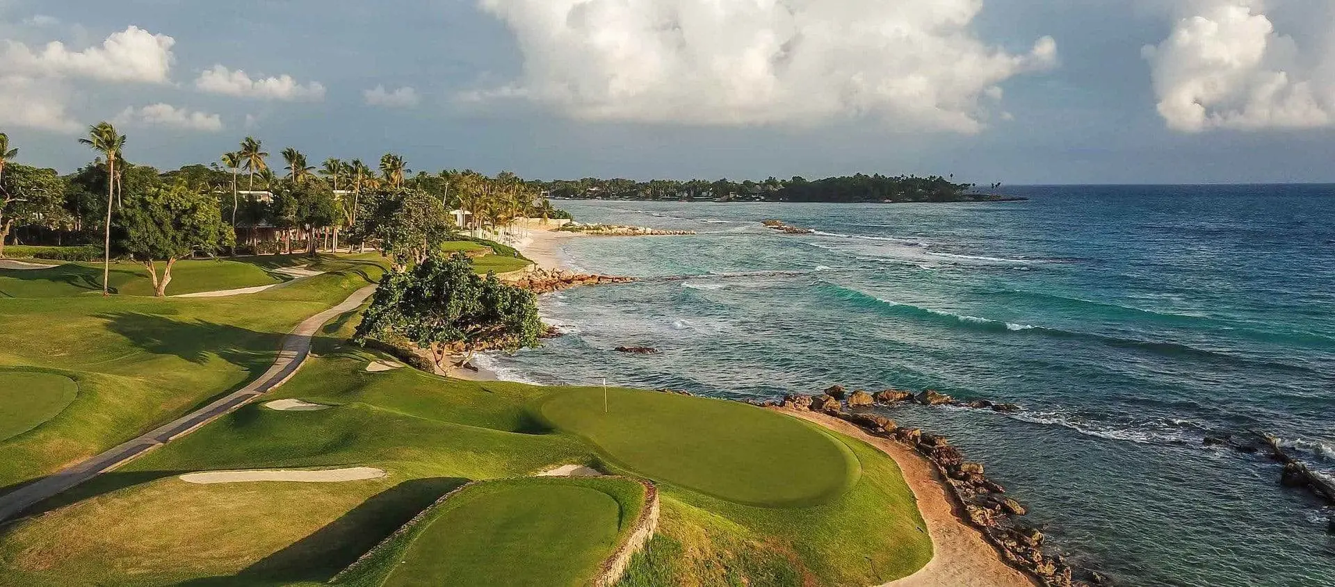 Panoramic view of the course with coastal views and a well-maintained green