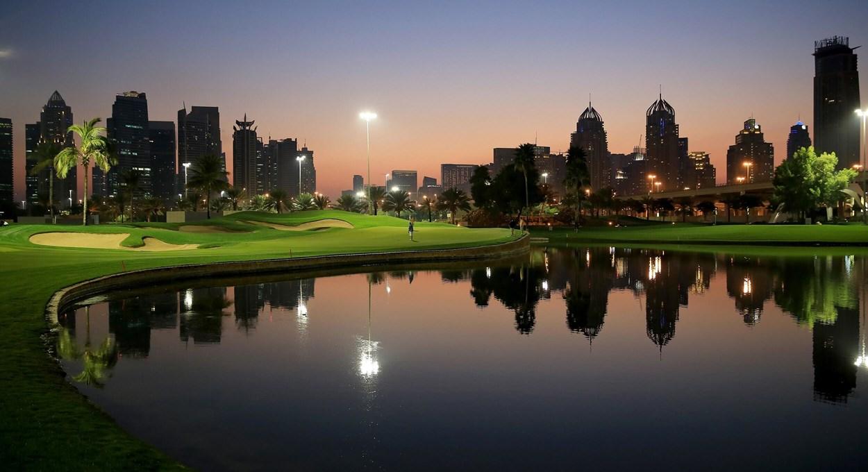 Golf course at dusk reflecting lights on a lake