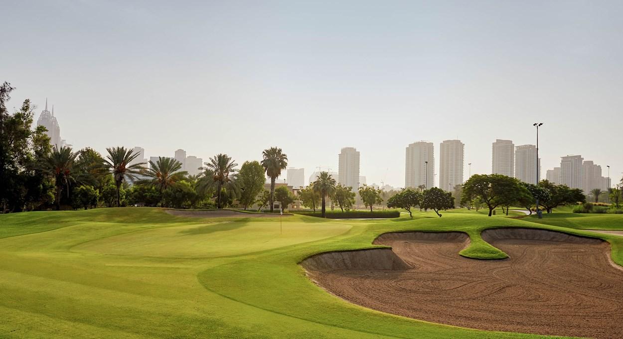 City skyline behind green fairway in Dubai