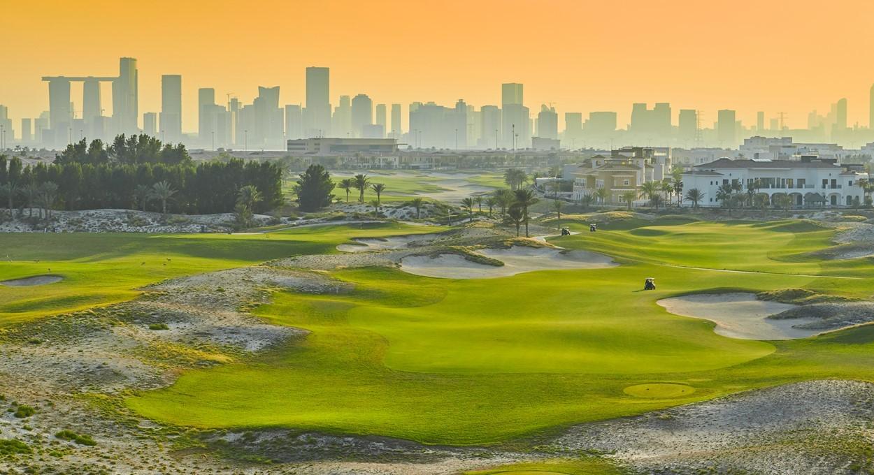 Golf fairway at sunrise with Dubai skyline