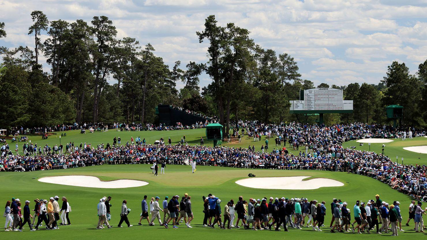 Crowds around Augusta National watching the action with the scoreboard in the background