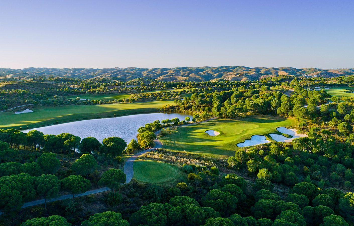 Aerial view of a smooth green surrounded by bunkers under clear blue skies