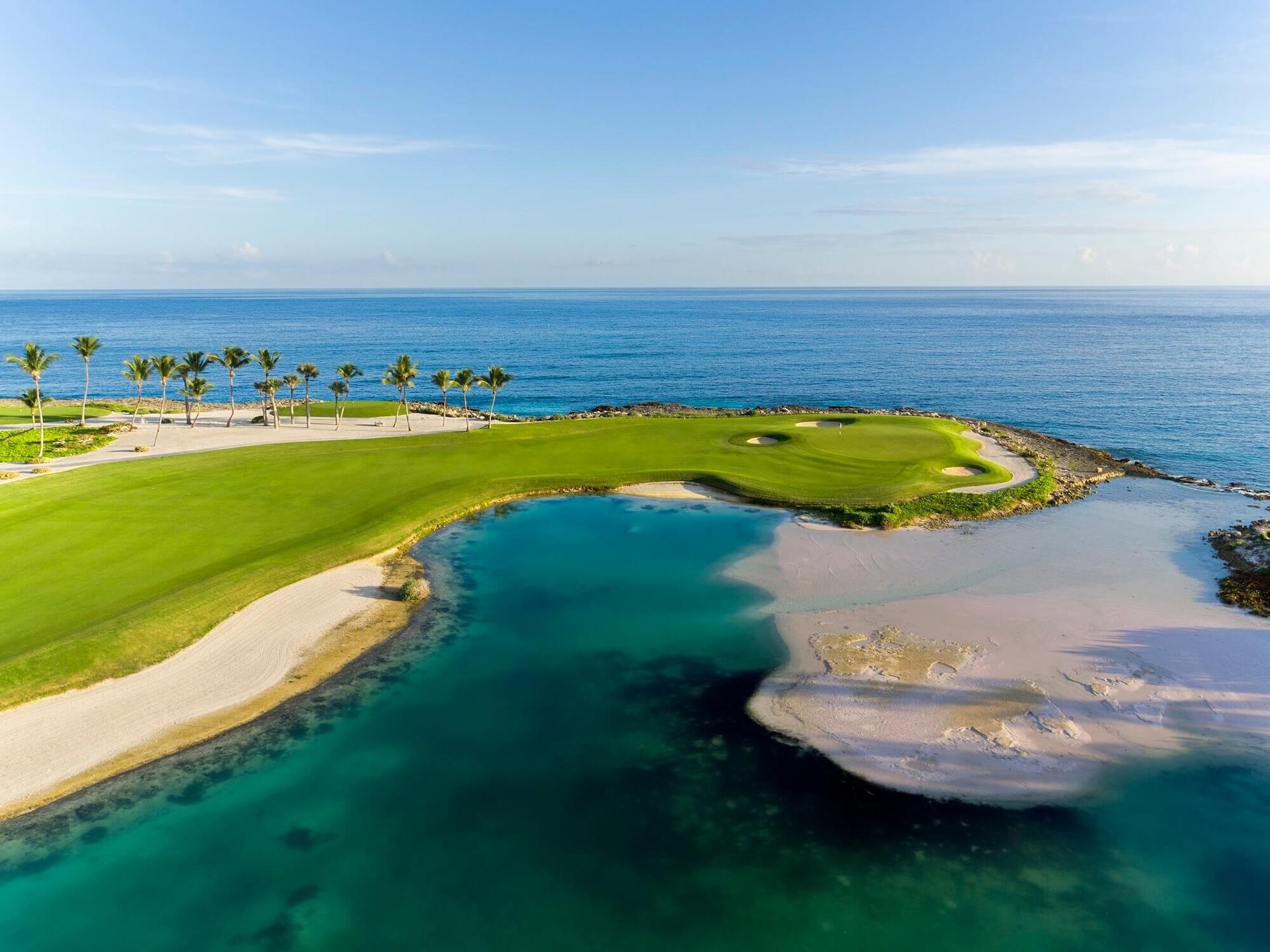 Overhead view of a well maintained fairway leading to a smooth green with coastal views