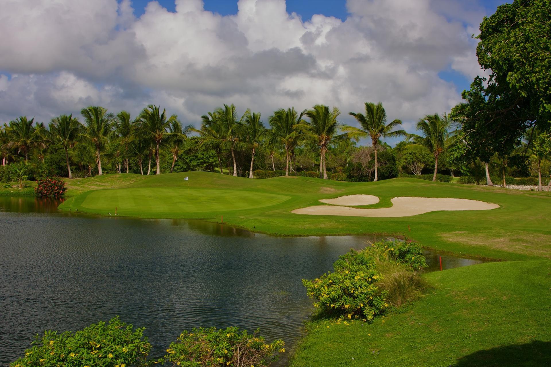 A smooth green strategically placed next to sand bunkers and a water hazard