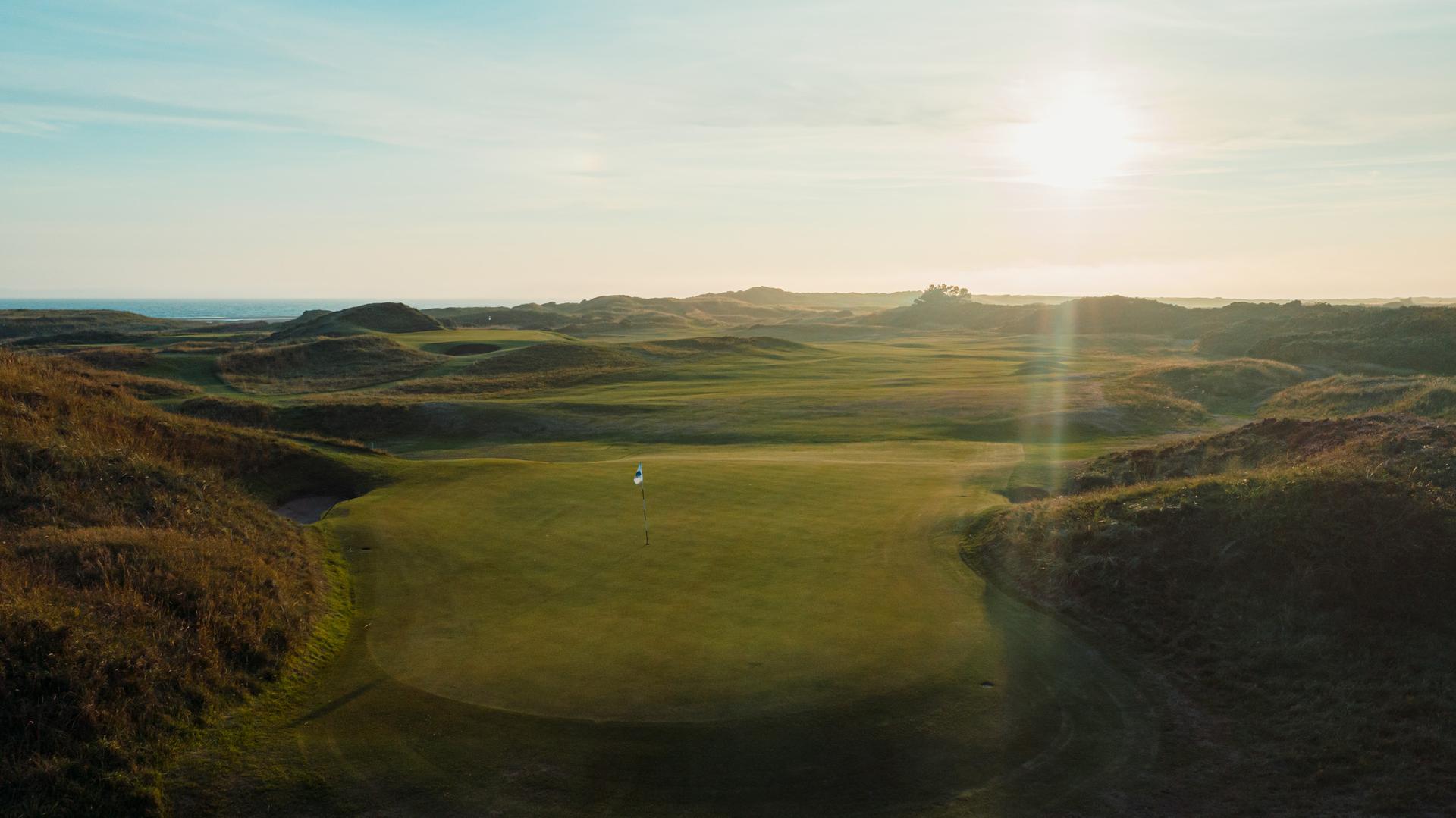 Classics links course at Royal Troon. A narrow, undulating fairway leading to a sloping green surrounded by thick rough
