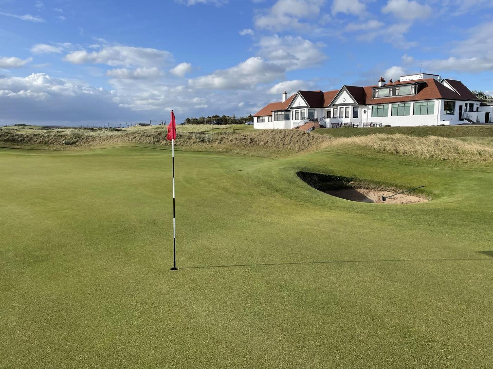 Undulating green with the clubhouse in the background at Western Gailes