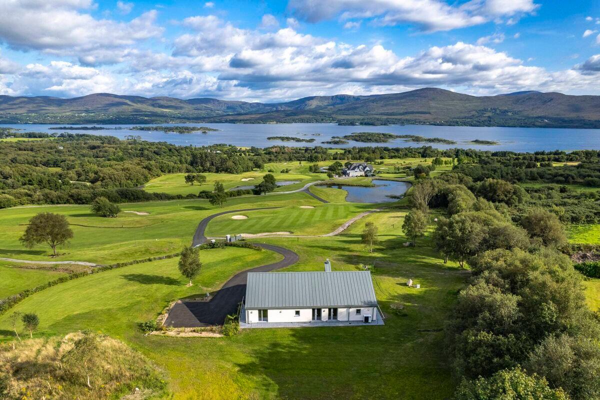 A stunning aerial view of the course with a modern clubhouse and lakeside views.