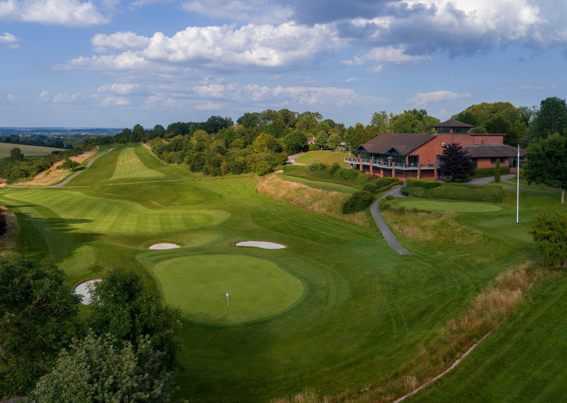 A wide straight fairway leading to a well-maintained green surrounded by sand bunkers