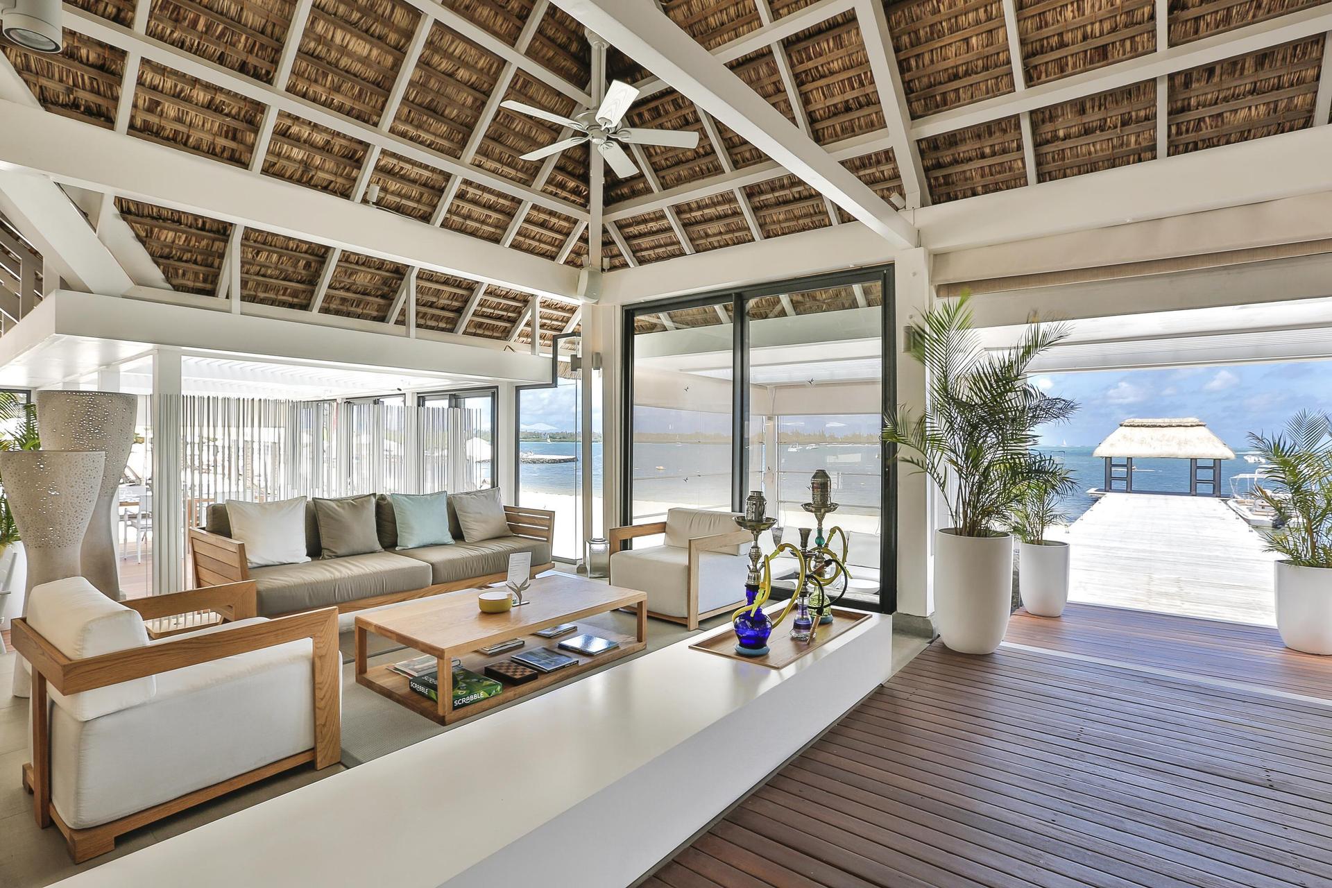 Indoor seating area with the option of shisha and a walkway towards the sea