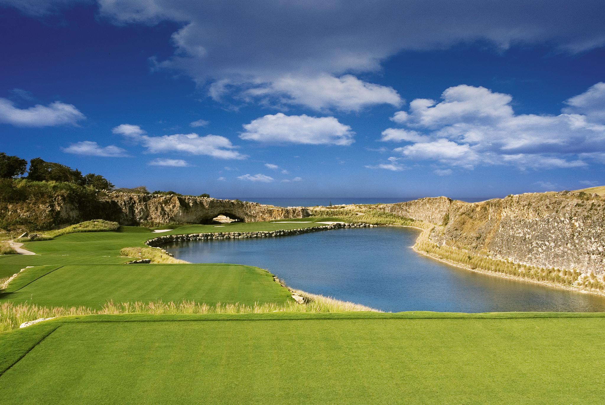 A large pond sandwiched between a large pond and a well-maintained fairway