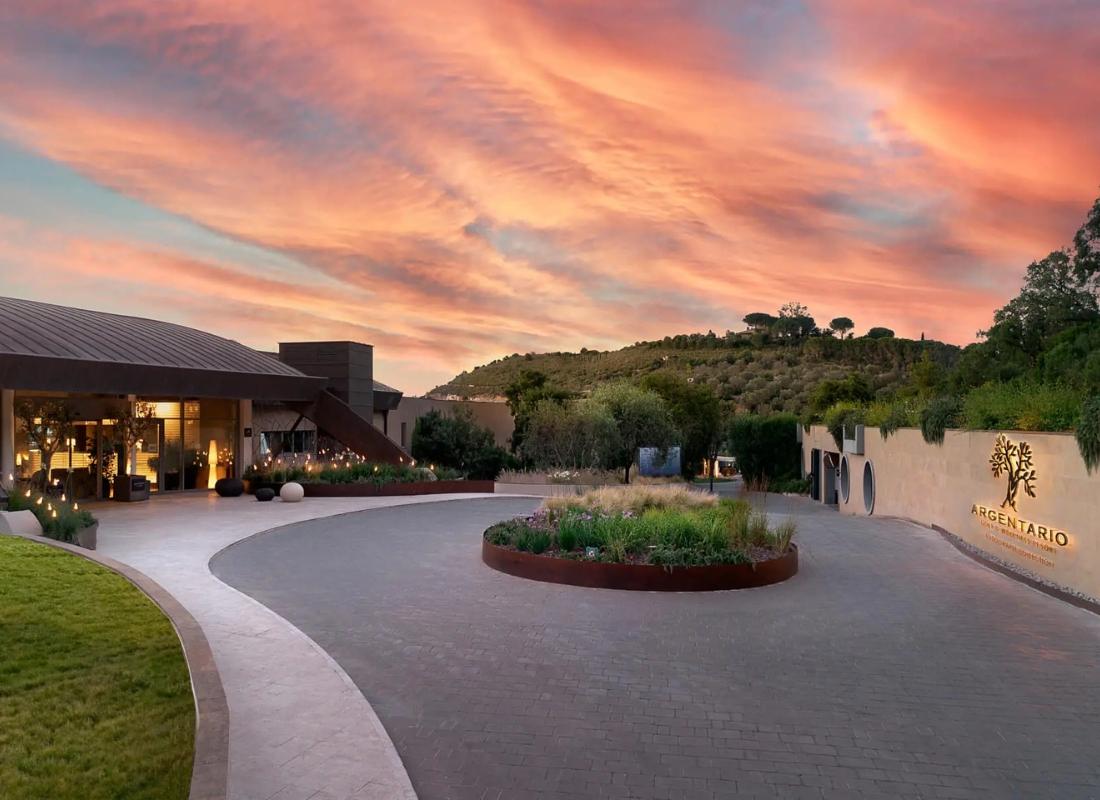 The front entrance to the Argentario Golf & Wellness Resort under evening skies