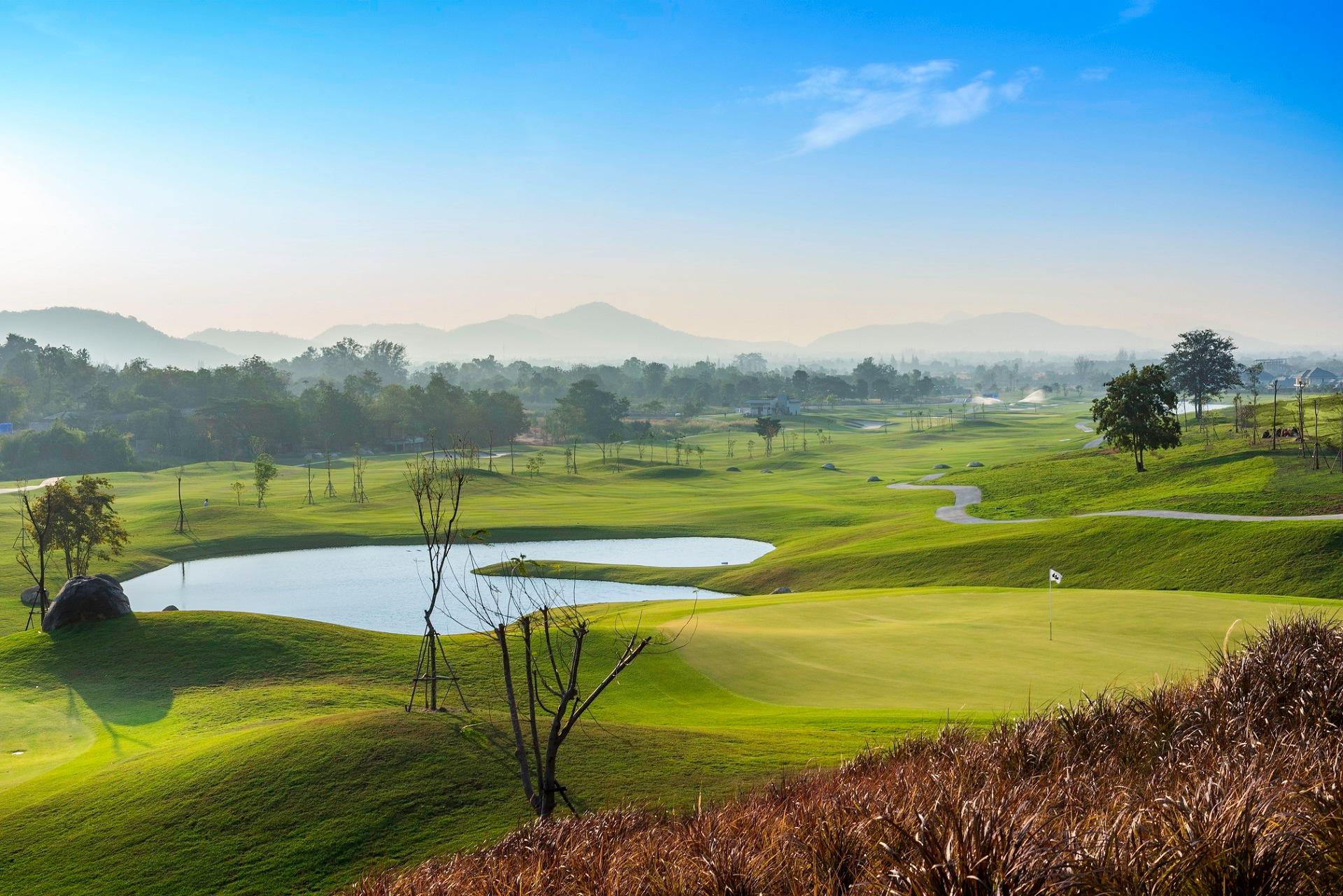 A well-maintained fairway leading to a smooth green placed next to a water hazard