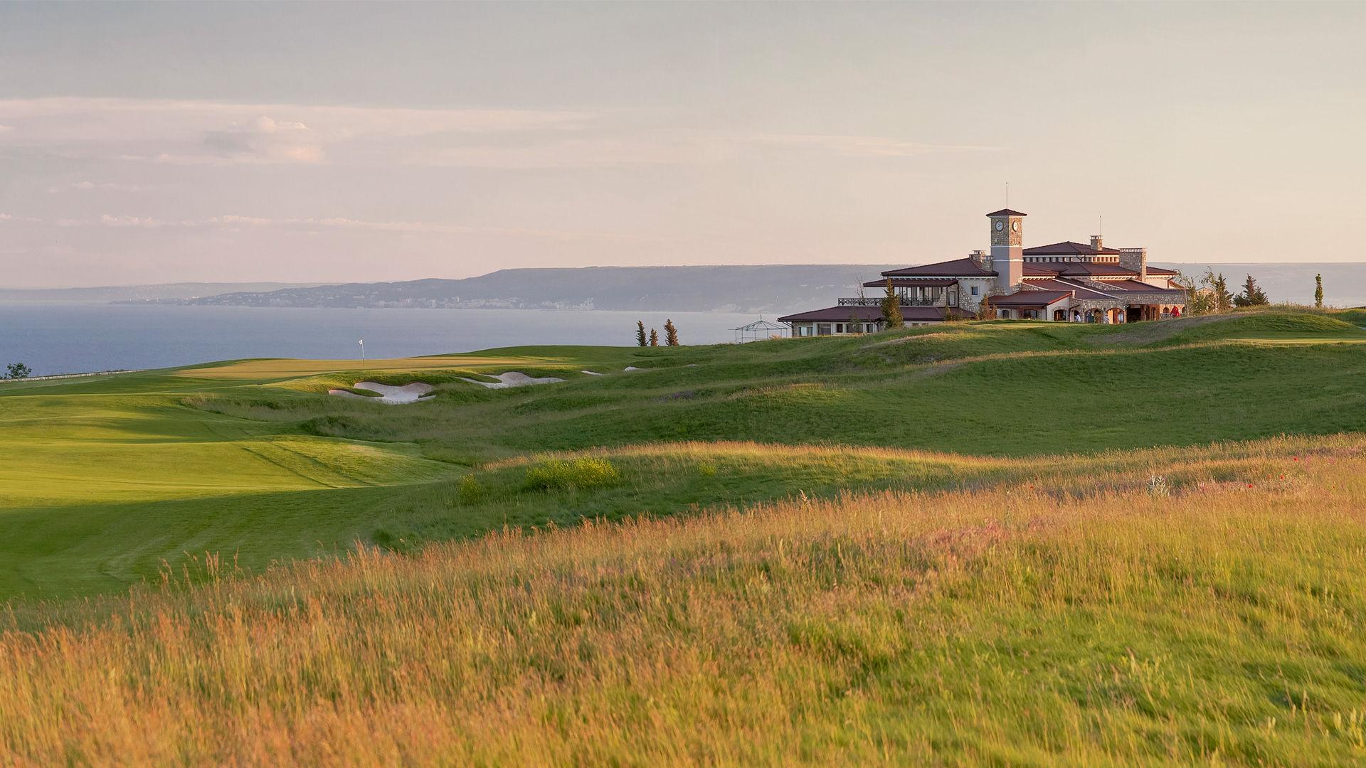 Rolling dunes surrounding a smooth green nestled with bunkers leading to the clubhouse