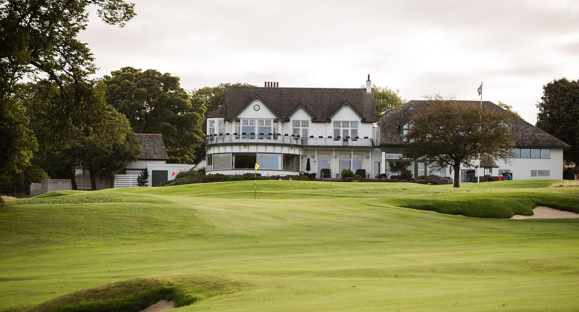 The clubhouse looking over manicured greens and sand bunkers on the course