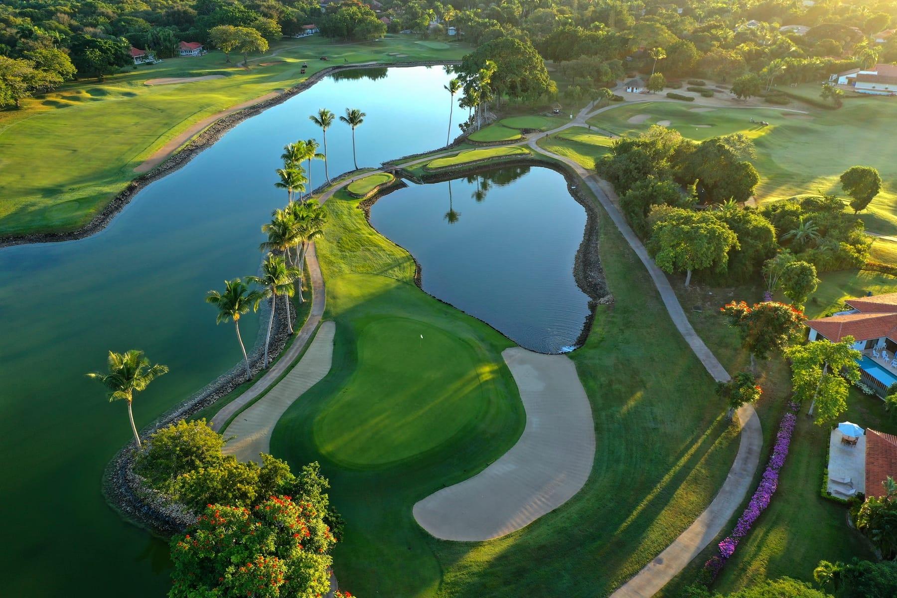 Aerial view of a manicured green nestled between two sand bunkers