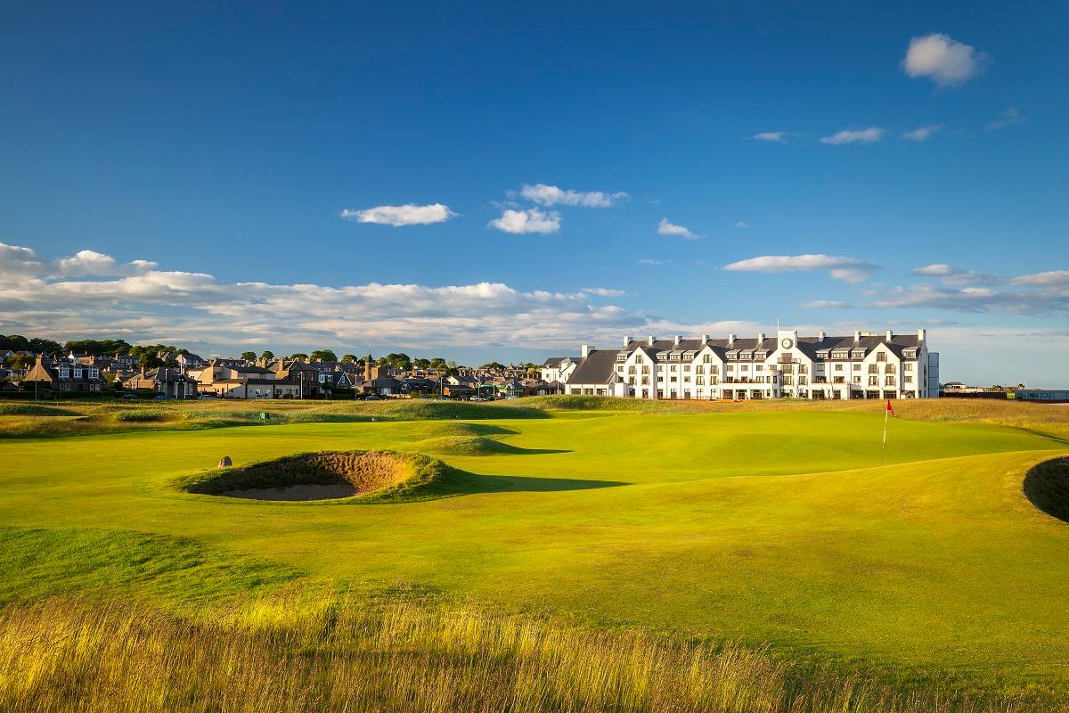 Rugged bunkers and rolling dunes leading toward the clubhouse and village.