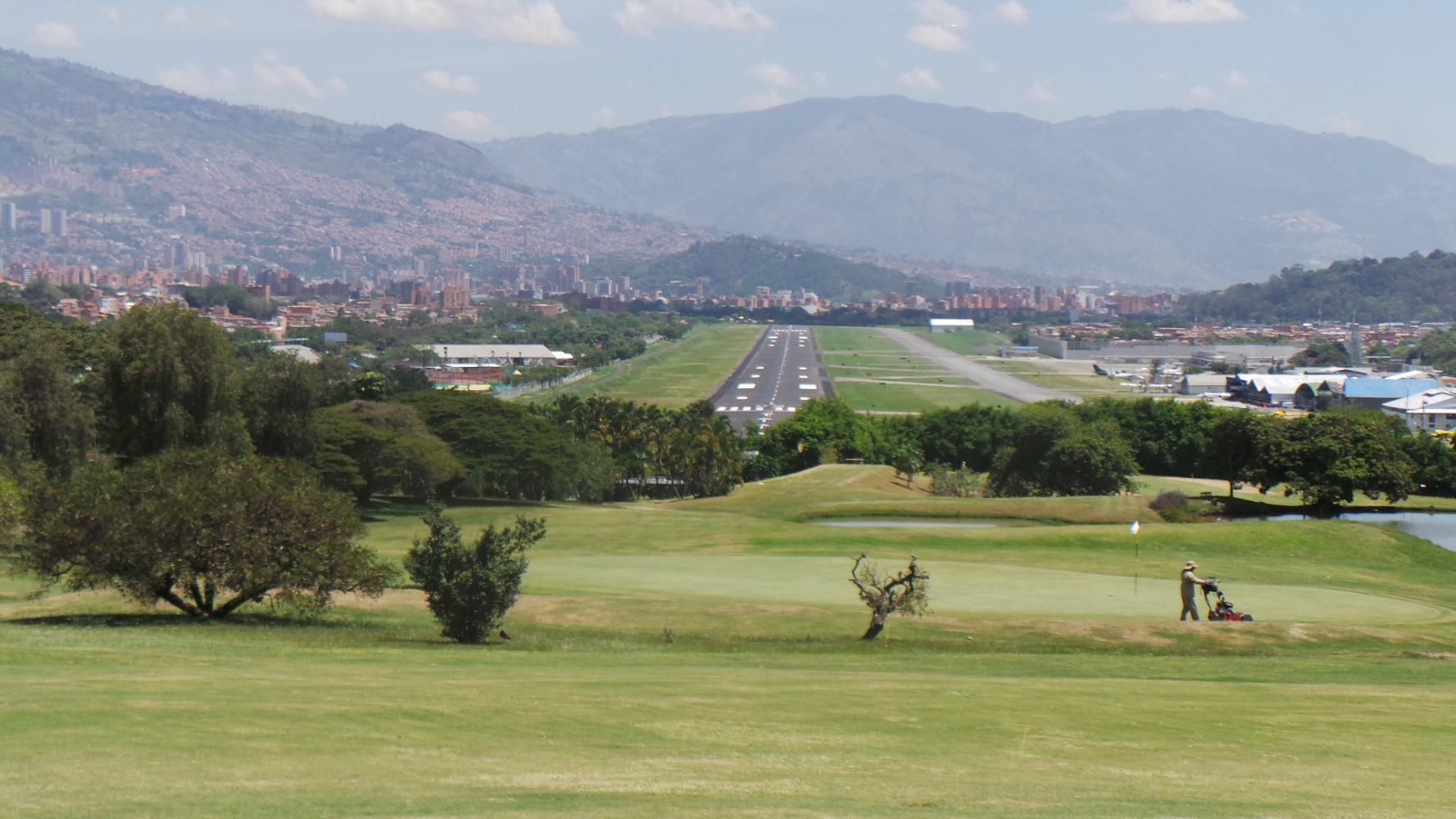 A smooth green with a view of the airport landing strip