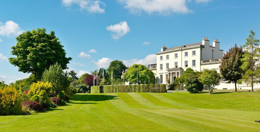 Beautifully landscaped lawn leading up to a luxurious resort.
