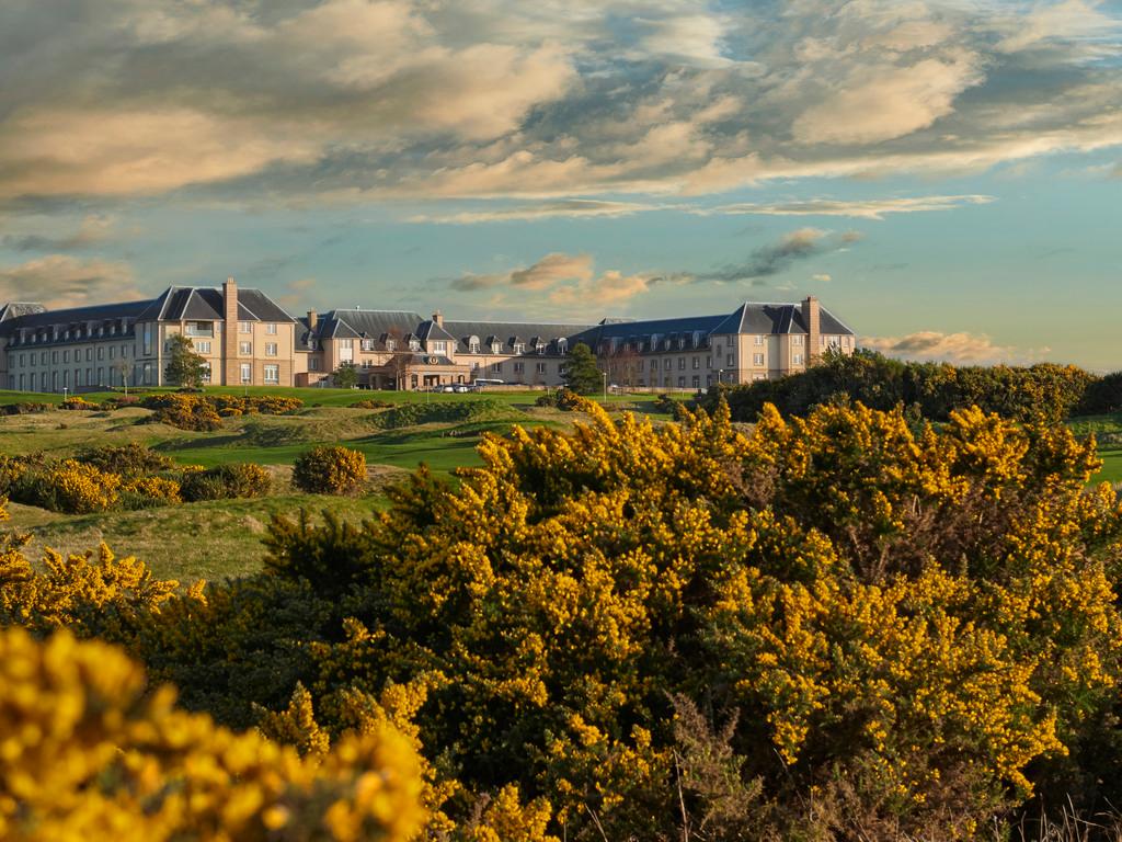 Resort nestled among green hills and golden coastal landscapes.