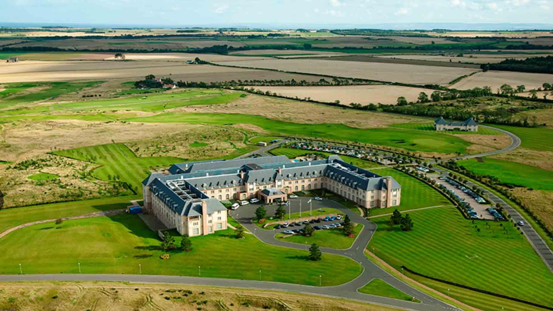 Aerial view of Fairmont St Andrews surrounded by rolling golf courses and coastline.