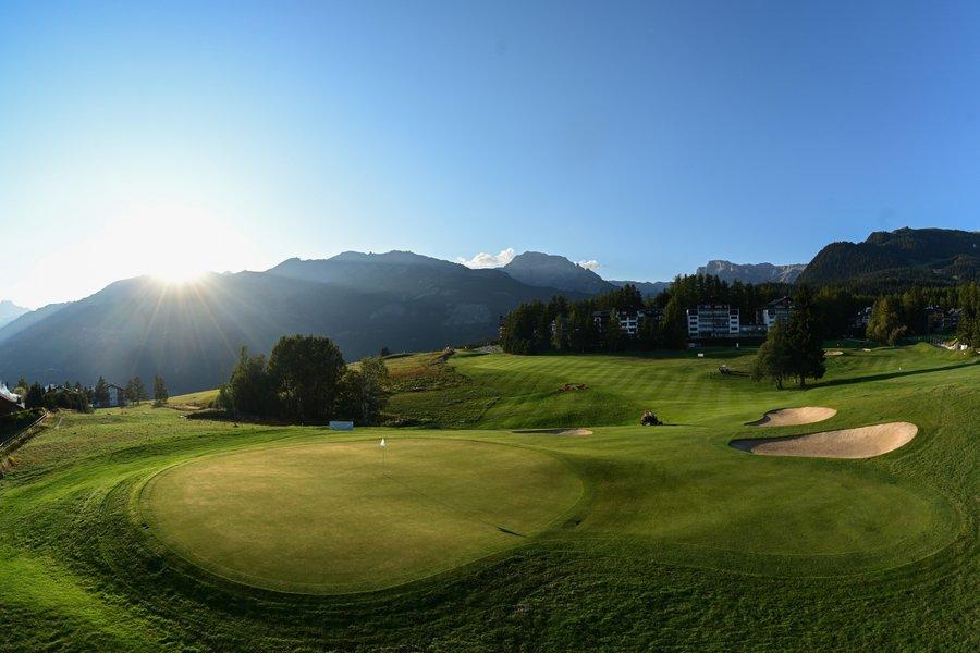 Sun shining onto a smooth green at the Golf Club de Crans Sur Sierre