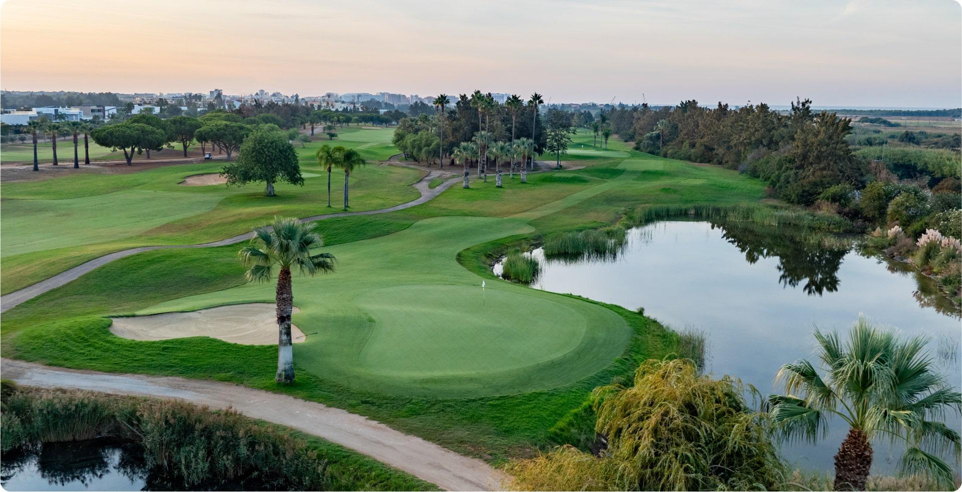 Undulating green with water around, at sunset