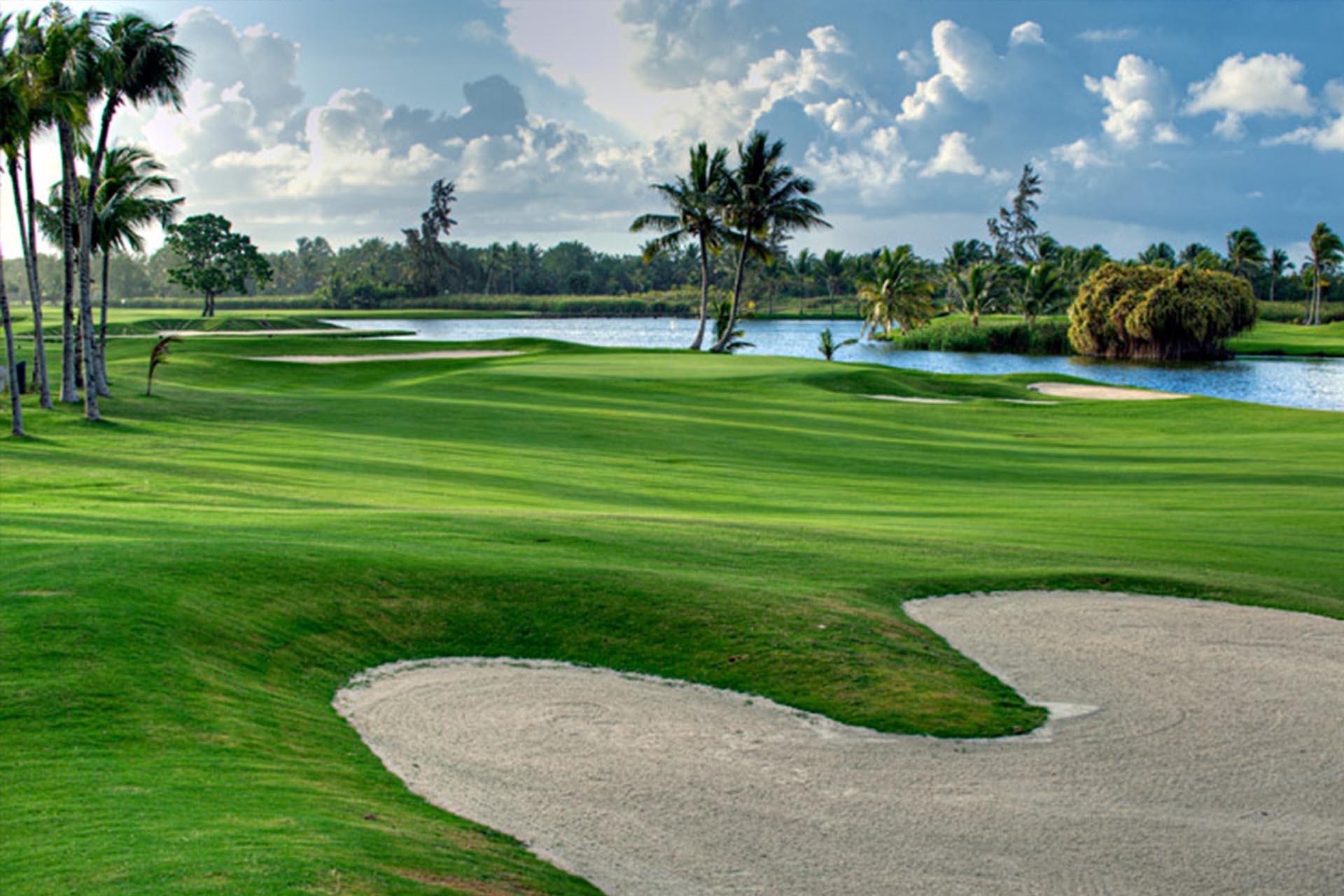 A large sand bunker leading to a manicured elevated green
