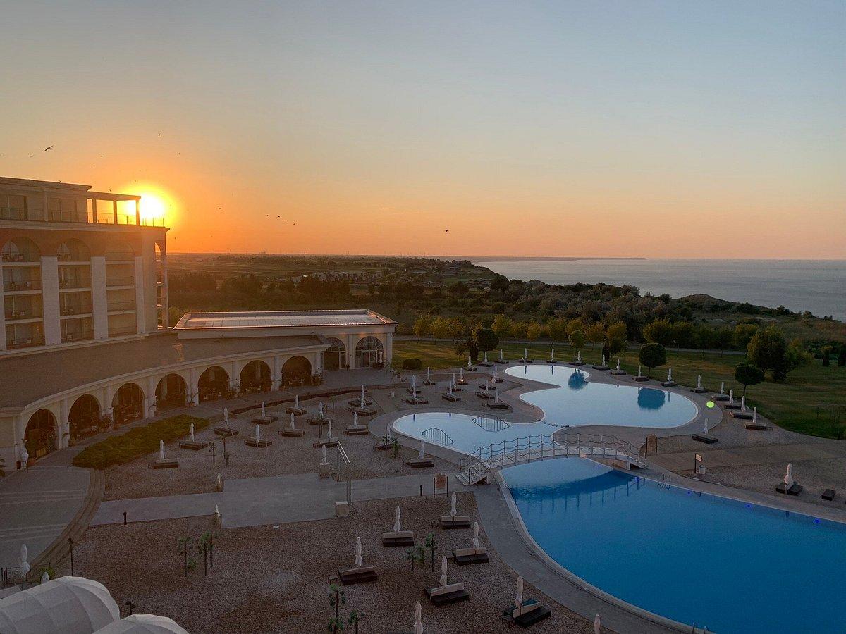 Golden sun setting over the swimming pool featuring a bridge to navigate to the other side