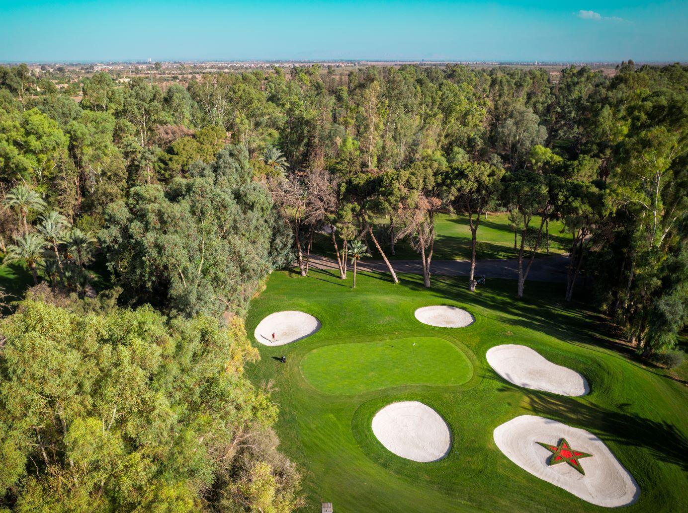 Aerial view of a green with sand bunkers, one featuring the Marrakech star design.