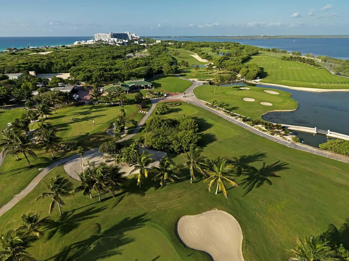 Aerial view of Moon Palace Golf Club showcasing lush fairways bordered by scenic ocean waters.