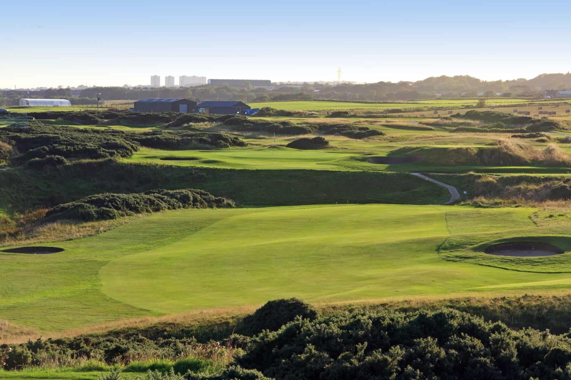 Well Kept greens and wide fairways with greenery in the background at the murcar course