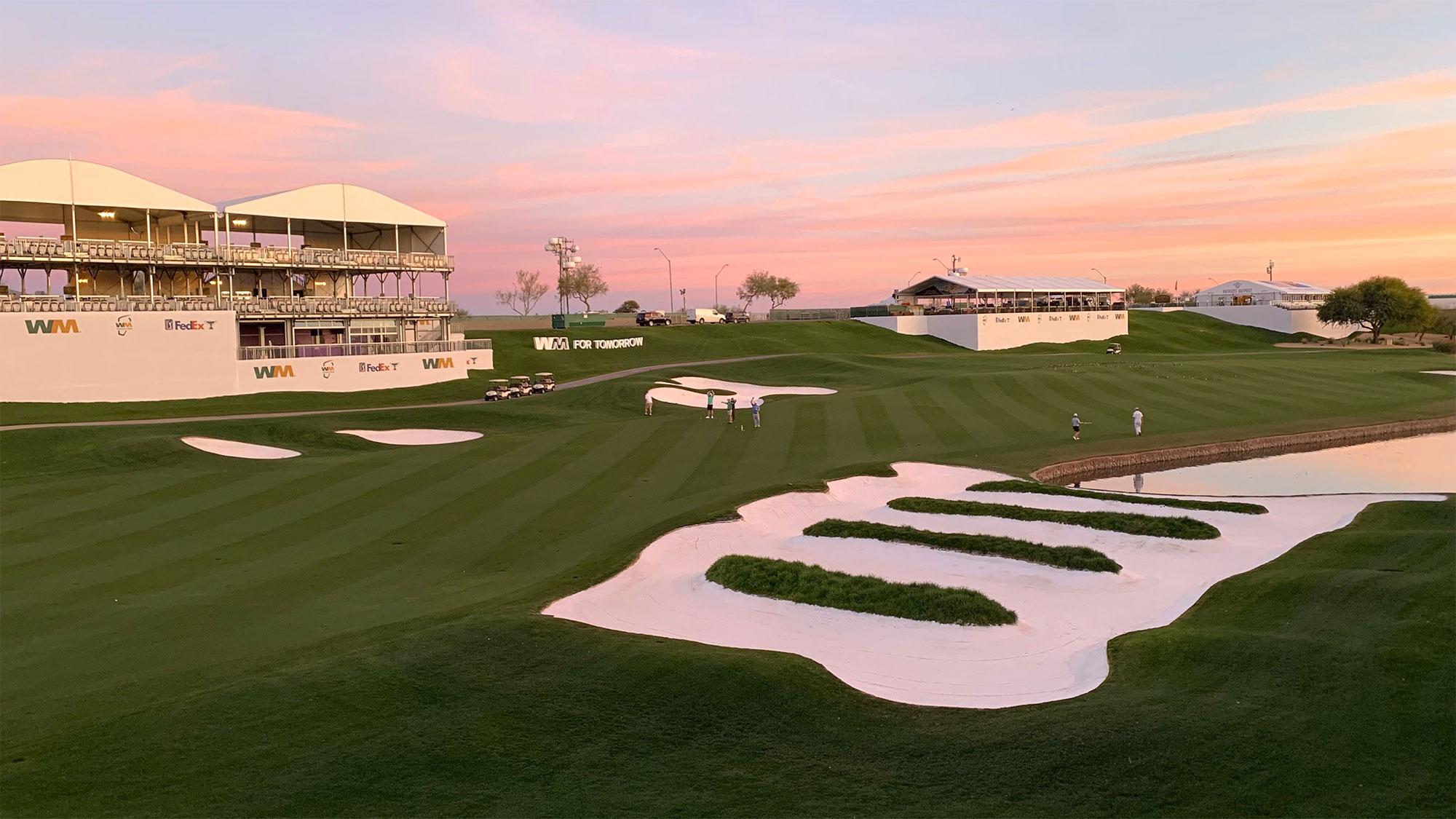 Sunset view of a green with grandstands set up for a PGA Tour event.
