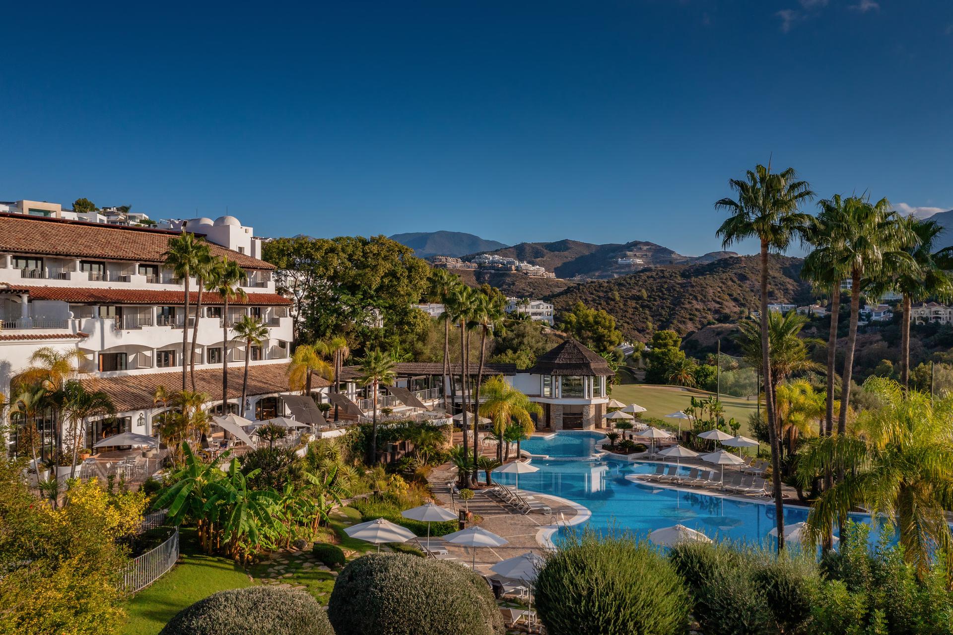 View of the hotel and swimming pool with mountains in the background