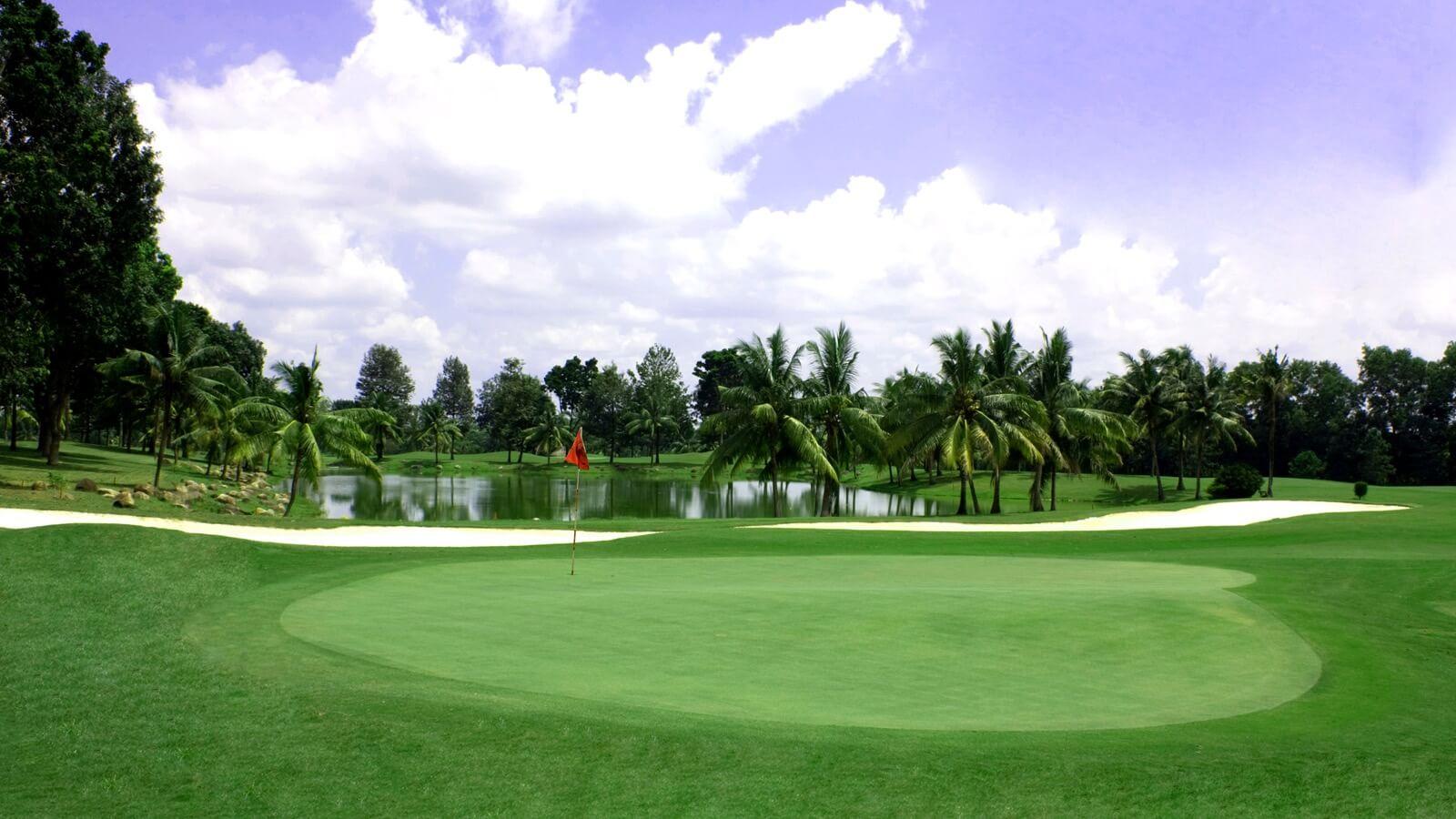 A smooth green surrounded by sand bunkers and a large water hazard