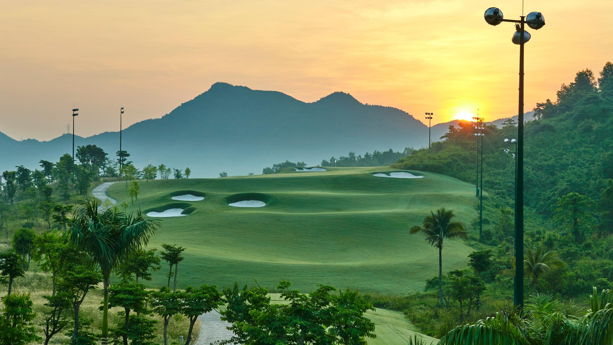 Panoramic view of a well maintained fairway at sunset with distant mountain views