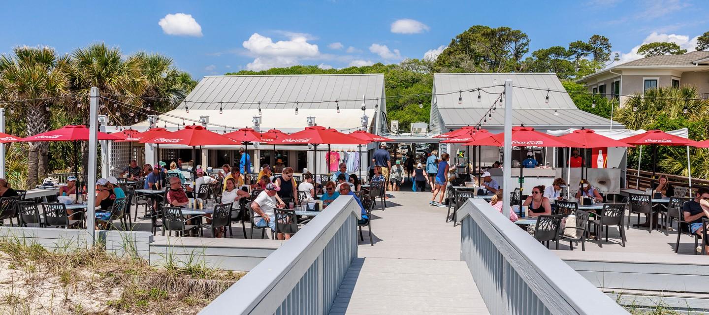 Outdoor restaurant as part of the resort with many dining tables protected by umbrellas