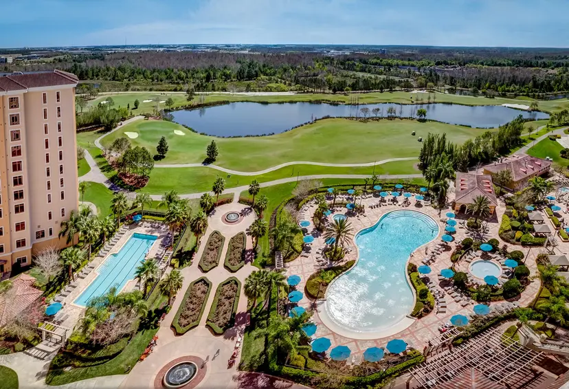 Aerial view of the hotel swimming pool's looking out to the on sight golf course featuring a large pond in the centre