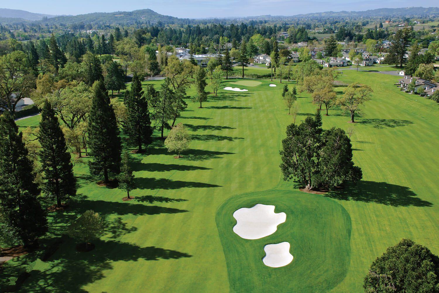 Overhead view of a well maintained fairway nestled with sand bunkers leading to a smooth green