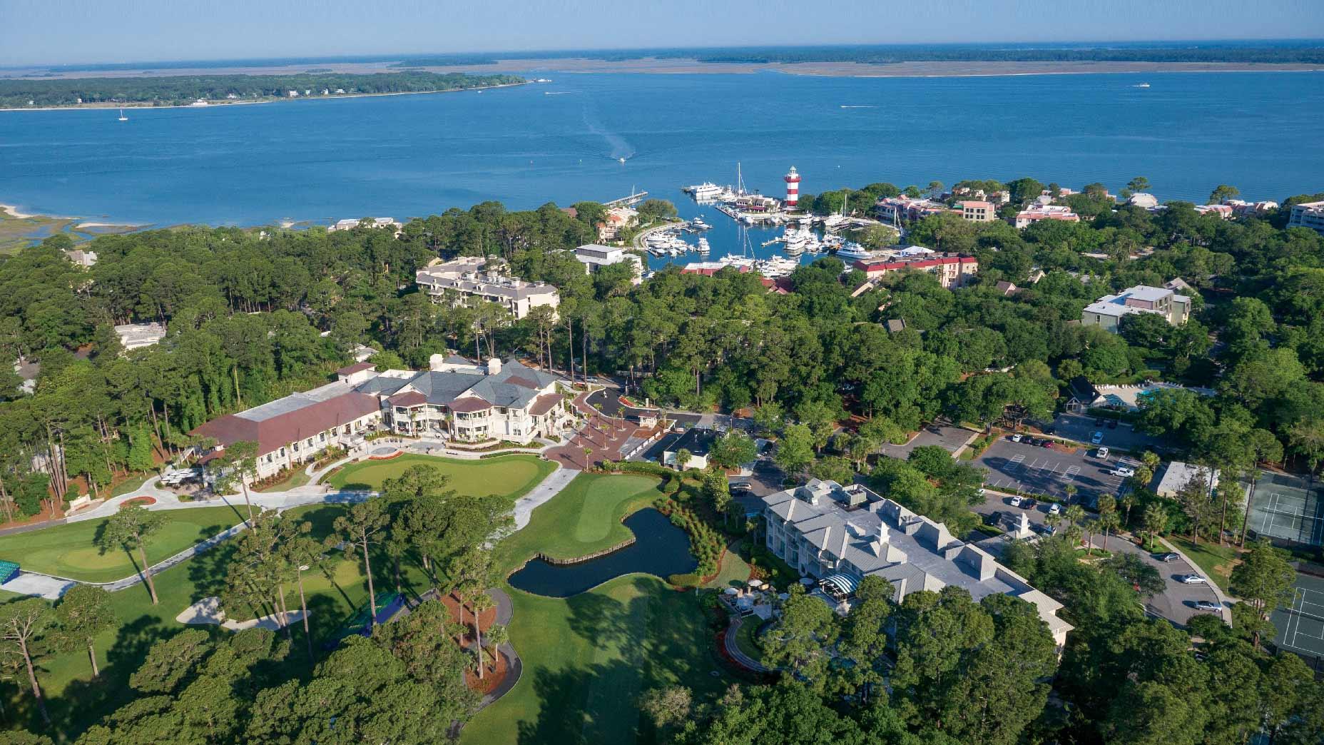 Aerial view of The Sea Pines Resort with a local dockyard in the distance alongside sea views