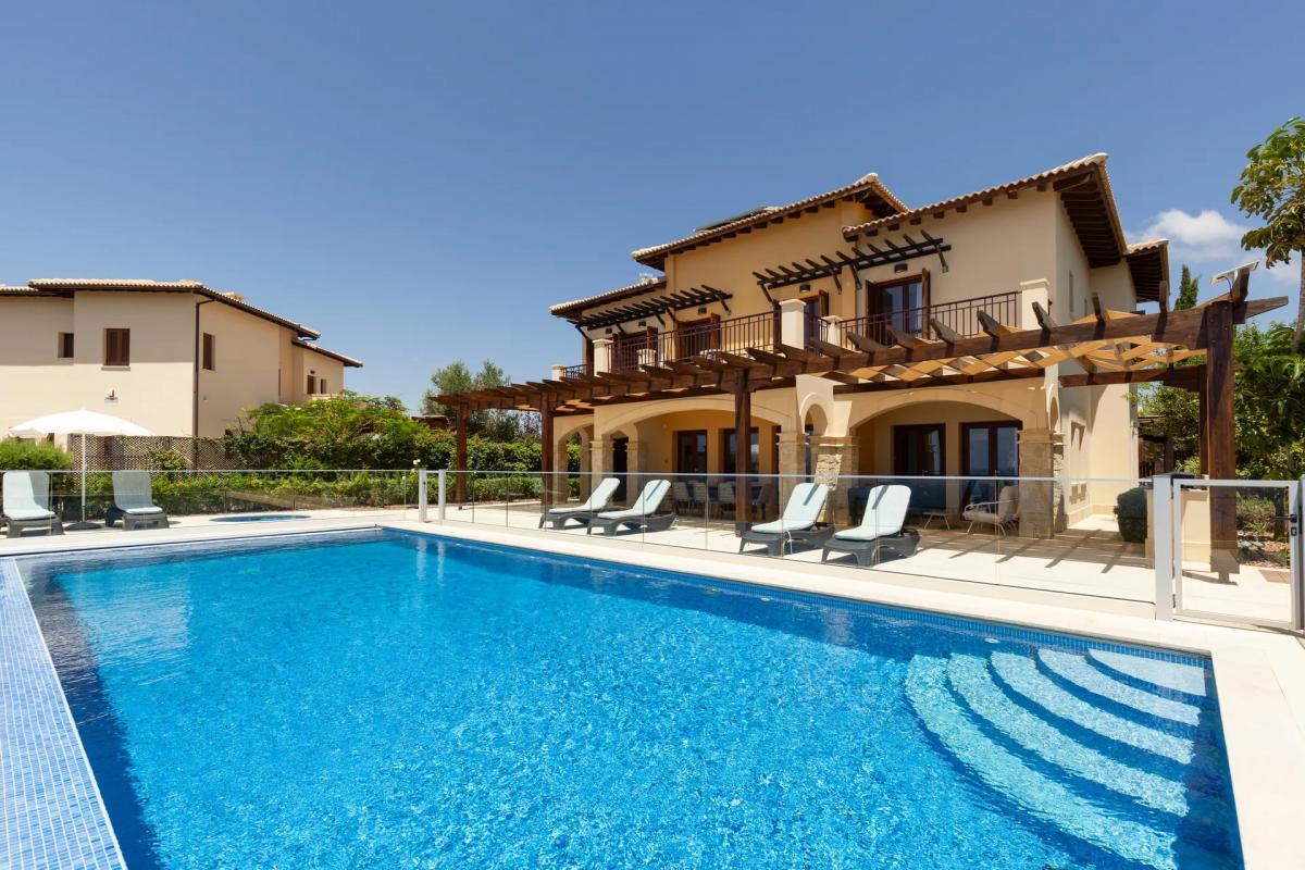 Large outdoor swimming pool with one of the resort buildings towering over