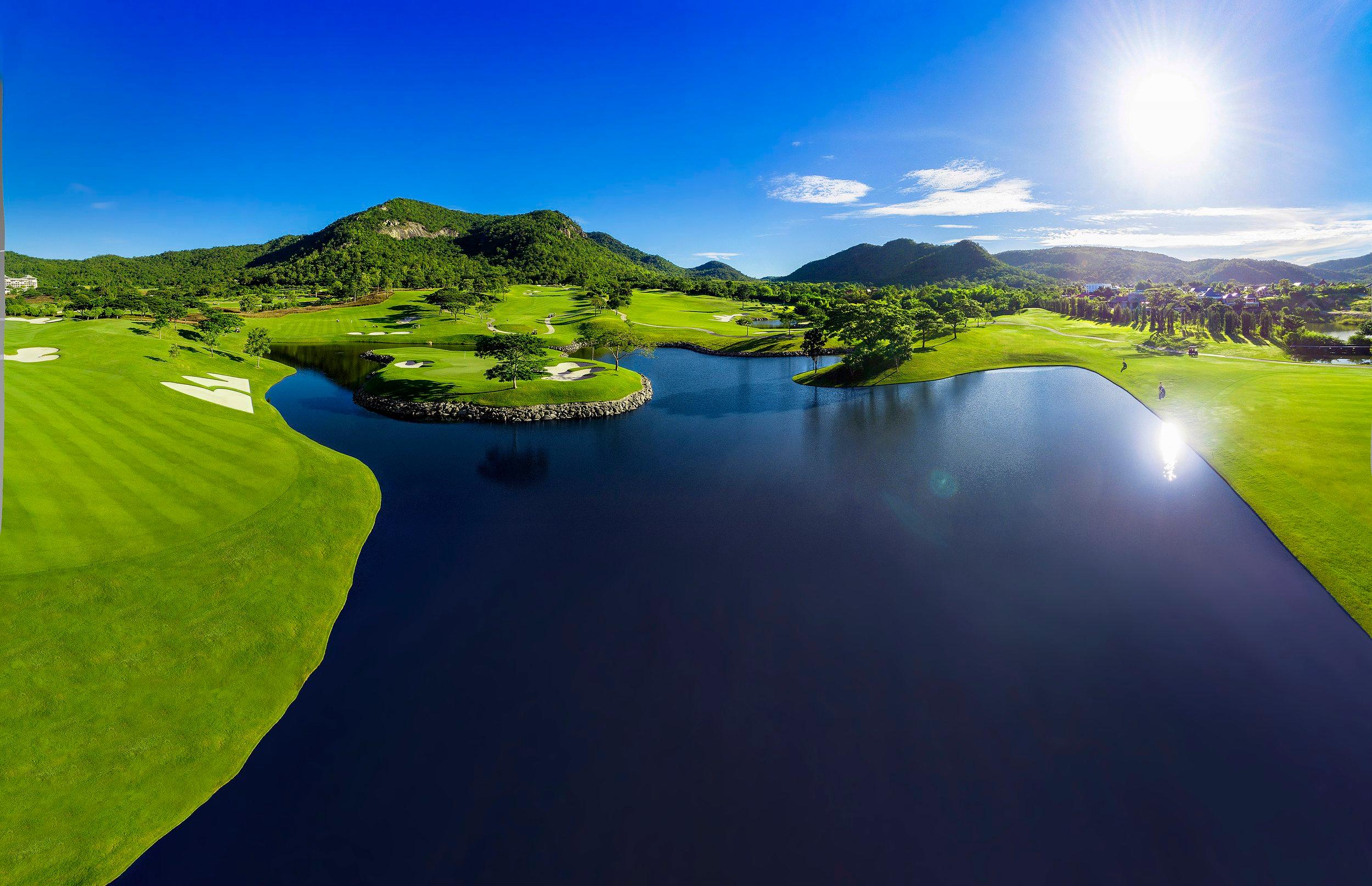 The sun shining over the Black Mountain Golf Course and reflecting off the water hazard