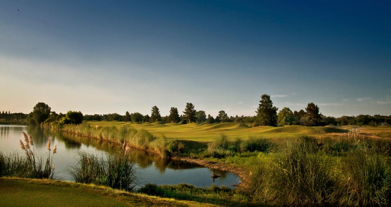 Undulating fairway with a water hazard on one side