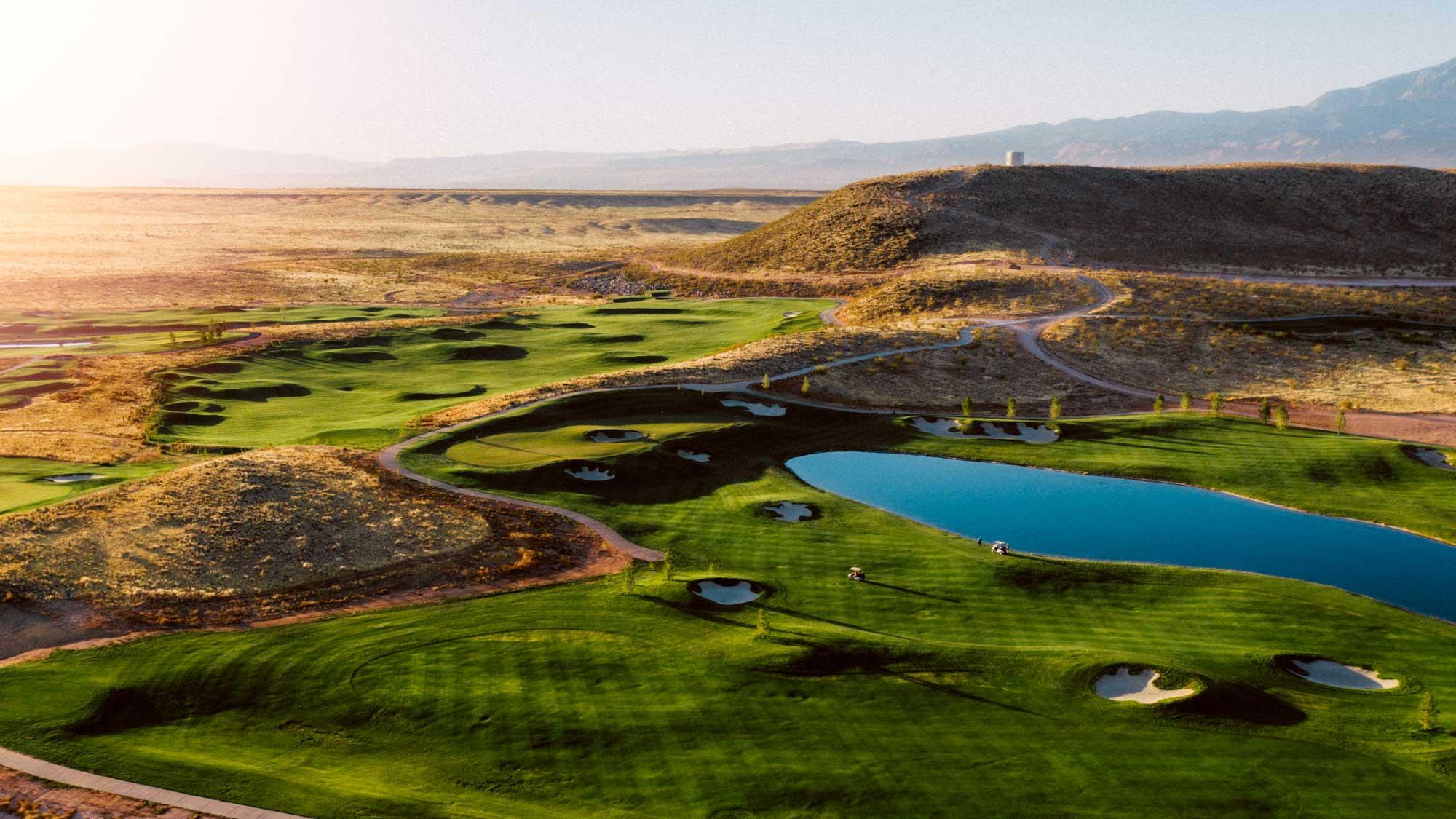 A desert course features rolling greens with numerous bunkers and a lake.