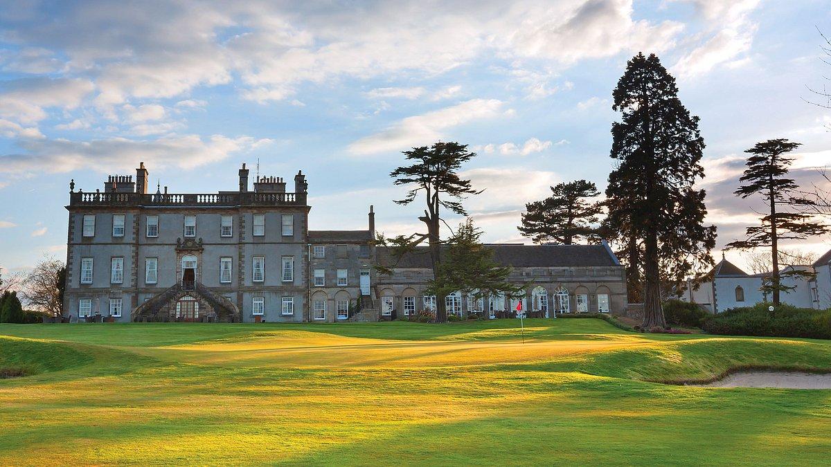 Dalmahoy resort building looking over the course with the sun shining down on the green