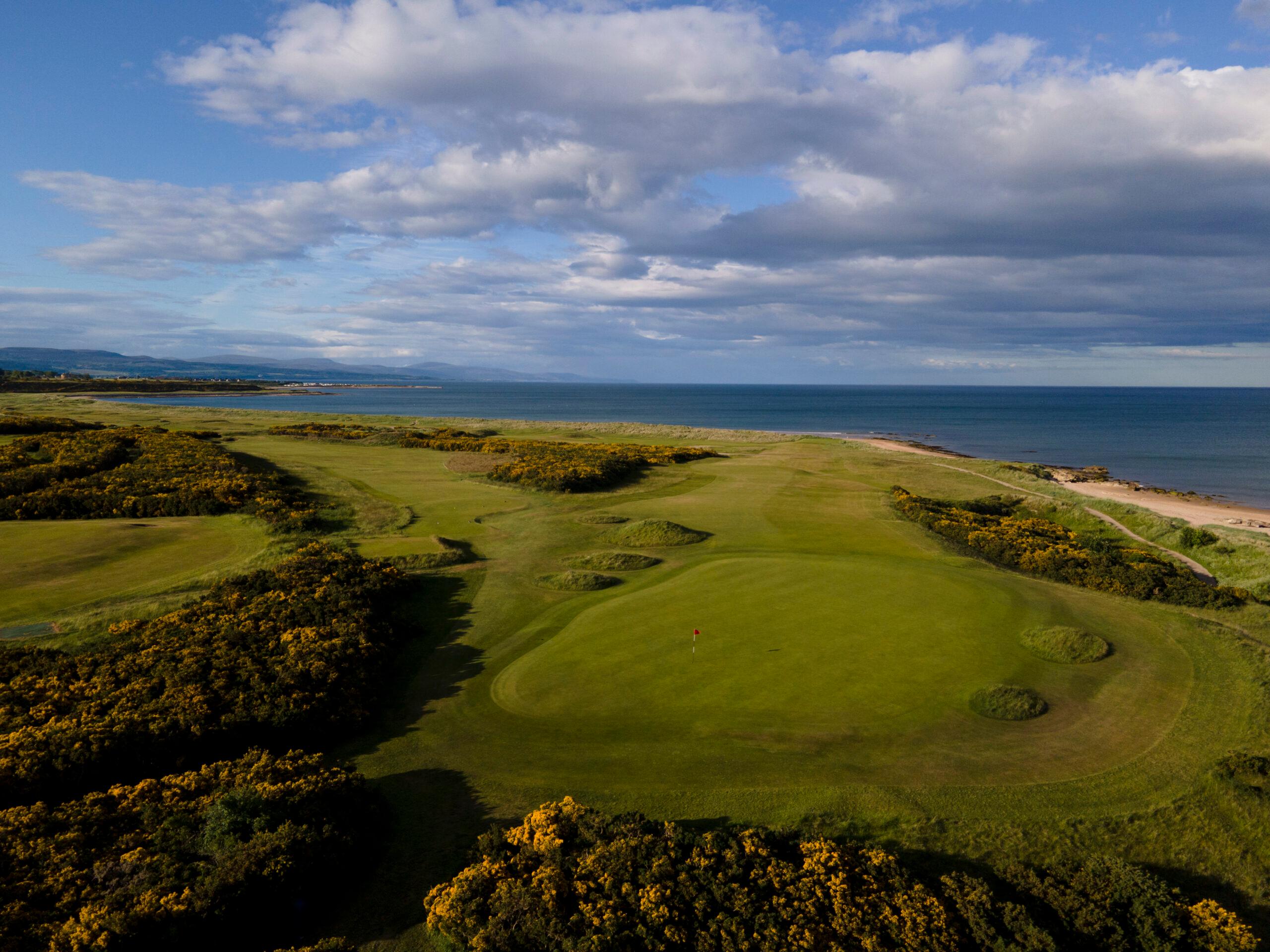 Manicured greens leading to coastal views