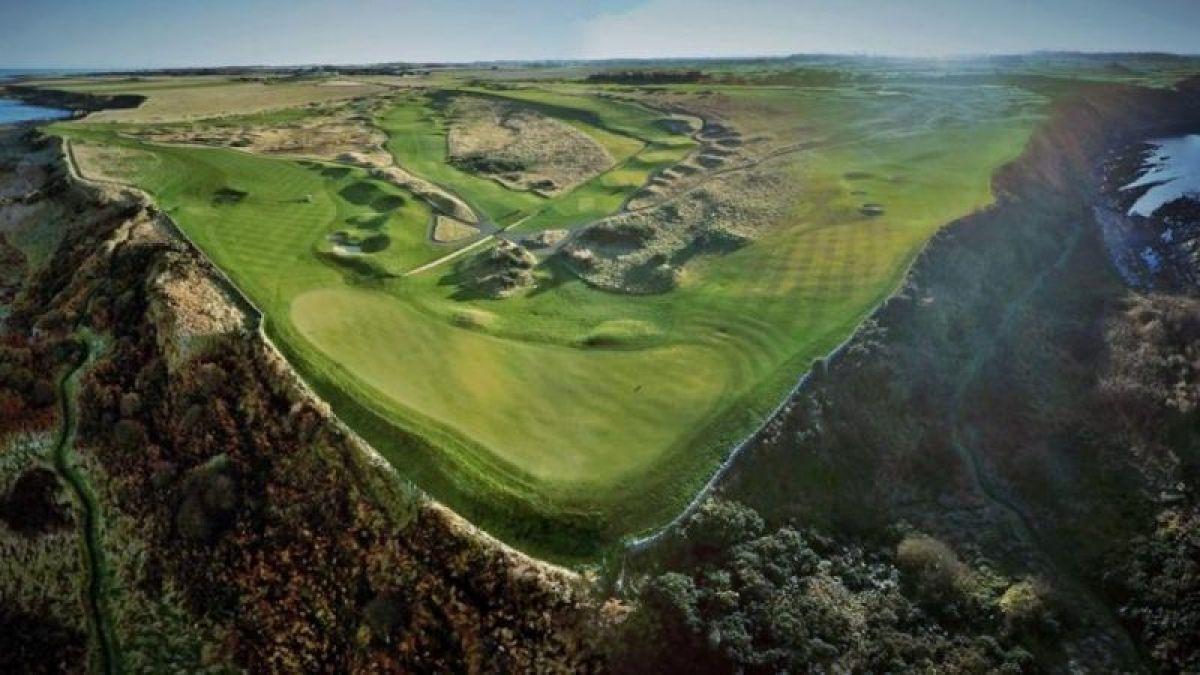 A dramatic clifftop golf hole surrounded by rugged terrain and ocean views.