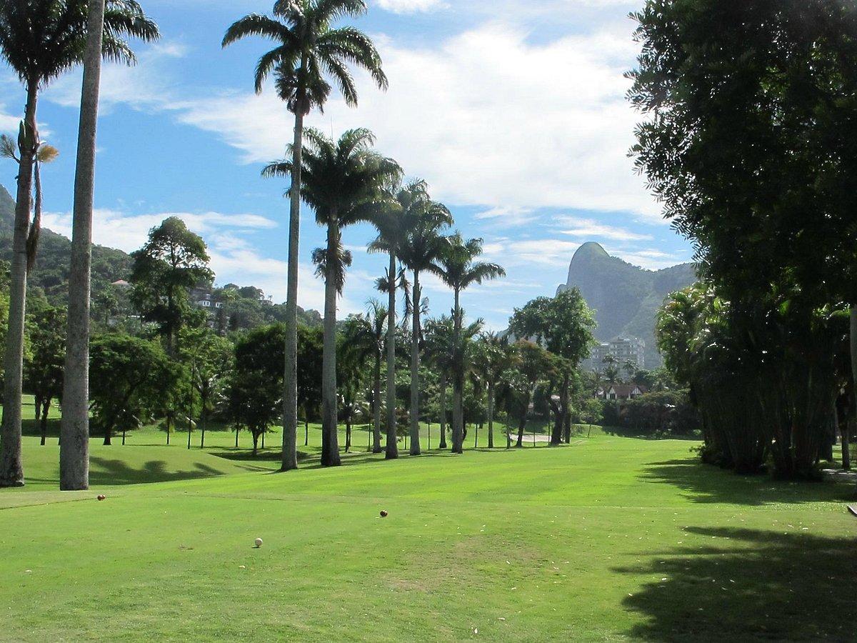 A palm-lined golf fairway with a mountain peak in the distance
