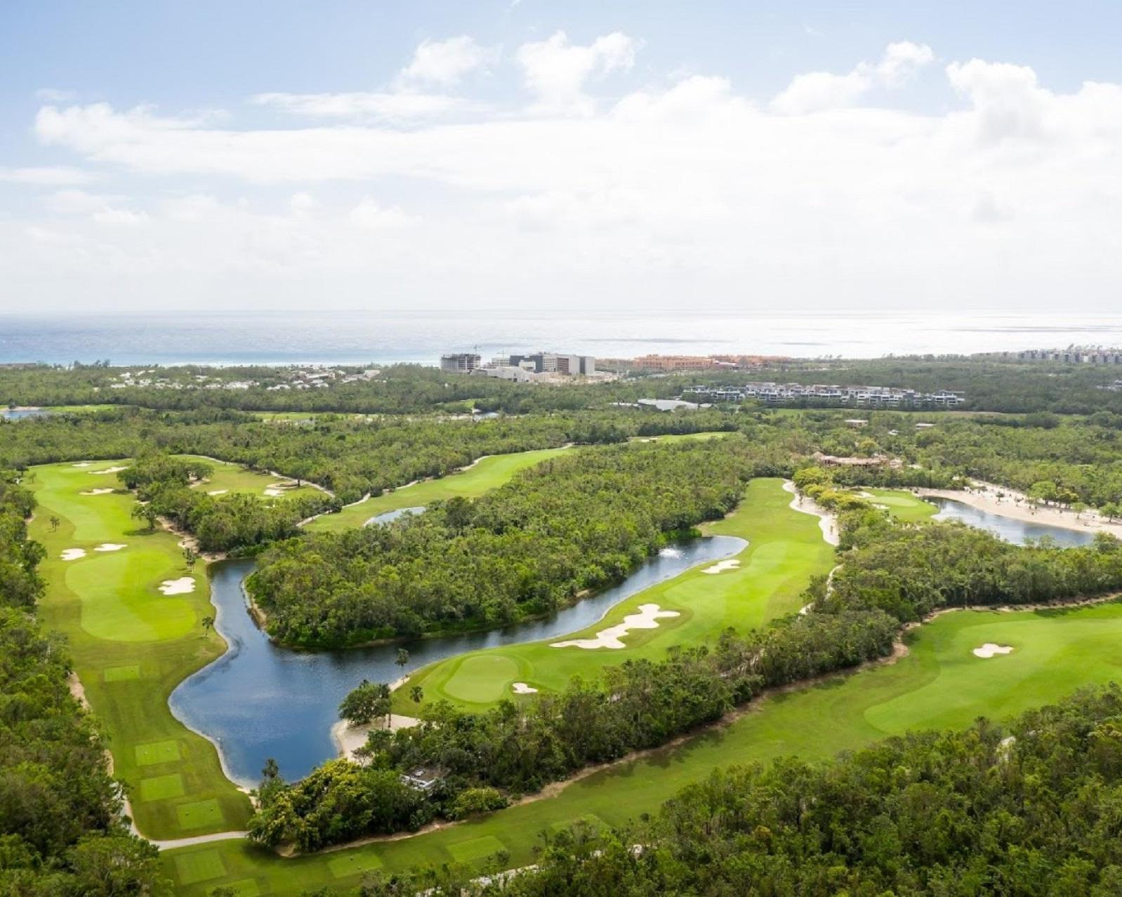 Aerial view of Gran Coyote Golf course with winding water hazards surrounded by dense tropical forest.